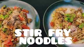 Cooking stir fry noodles with farmer's sausage, black bean paste, pointed cabbage and bell pepper
